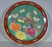 PLATO JAPONES, de porcelana recubierta de esmaltes polícromos con decoración de aves y flores. Fisura. Diámetro: 34 cm.