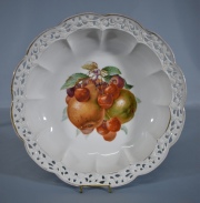 CENTRO DE BAVARIA, de porcelana alemana con decoración de frutos polícromos. Borde lobulado y calado. Diámetro: 23 cm.