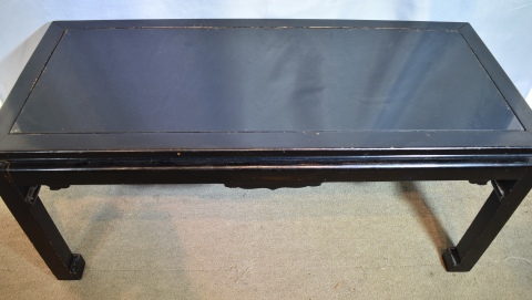 MESA BAJA ESTILO ORIENTAL, de madera laqueada en negro. Tapa de vidrio pintado de negro. Desgastes. Alto: 43 cm.