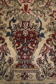 ALFOMBRA PERSA, con diseño de tres vasos con rameados, flores y aves polícromos. Mide 200 x 134