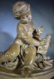 Niño con paloma, terracota firmada Pigalle. Alto: 35 cm. Frente: 32 cm.