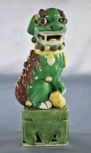 PERRO DE FO, de porcelana china recubierto de esmalte verde, amarillo y aubergine. Alto: 20 cm.