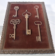 Cinco antiguas llaves de hierro en un marco.