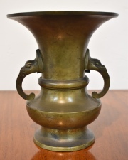 Vaso de bronce Chino con cabezas mitológicas. Alto: 26 cm. Diámetro: 21 cm.
