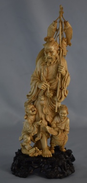 PESCADOR CON NIÑOS Y PESCADOS, figura china de marfil finamente tallada. Base de madera con ornato de troncos y hojas ca