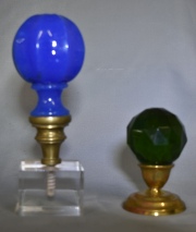 Dos pomos para escalera distintos. uno de opalina turquesa y base de bronce, el otro de vidrio verde facetado. Alto: 2