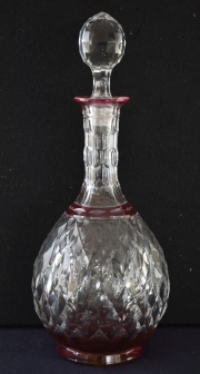 Dos botellones de cristal tallado, color rubí y neutro con tapones. Alto: 32,5 cm.