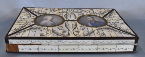 Caja con incrustaciones, faltantes. Tapa con dos miniaturas. Mide: 31 x 18,5 cm.