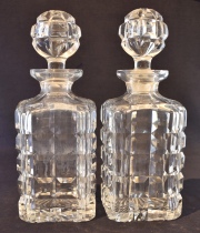Par de botellones de cristal rectangulares, con tapón. Alto: 25,5 cm.