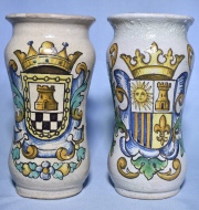 Dos floreros italianos, de cerámica policromada con decoración de escudos heráldicos. Alto: 24 cm.
