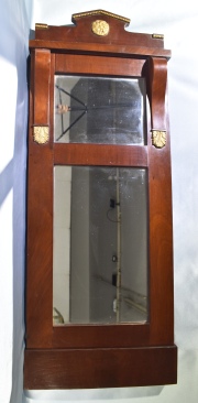 Espejo de pared Rectangular, estilo imperio. Enchapado en caoba. Alto: 105 cm. Frente: 41 cm.