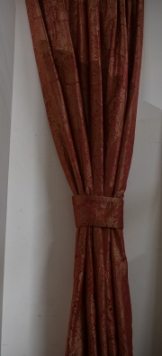 Cuatro hojas de cortinados en seda de fondo rojizo con motivos de flores. Alto: 320 cm. Ancho inferior: 196 cm.