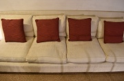 SOFA DE CUATRO CUERPOS, tapizado en tela beige. con almohadones.