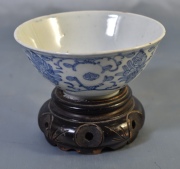 Bowl de porcelana oriental, con base de madera. Diámetro: 14 cm.