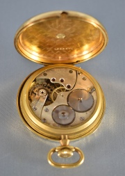 Reloj de bolsillo Longines, caja de bronce y esfera con núm. arábigos. Tapa trasera de oro 18 k. Desgastes. Diám. 4,8 cm