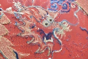 TAPIZ CHINO, de lana y seda con ornamentación de personaje con dragón en tonos rojizos y azulinos.