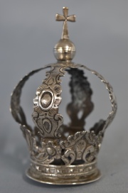 CORONA DE SANTA, de plata repujada con motivos vegetales, remate con cruz y bola. Alto: 10,5 cm. Peso: 47 gr.