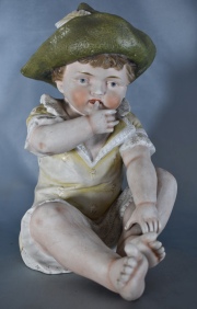 NIÑO CON SOMBRERO, figura de porcelana policromada. Un dedo faltante. Alto: 29 cm.