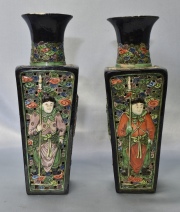 Par de jarrones chinos de porcelana con figuras de guerreros sobre esmalte negro. Restaurados. Alto: 28.7 cm.