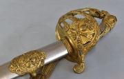 Sable, guardamano de bronce con alegoría de la guerra dorado. Hoja del año 1893, manufactura de Toledo. 98 cm.