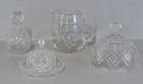 Cuatro piezas de cristal: Jarra, campana, pequeño perfumero y mantequera con tapa. Alto jarra: 16 cm.