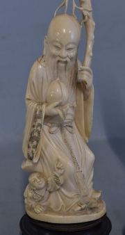 Hombre con fruto, tallas chinas de marfil, faltante en el bastón y Dama con flores. 2 Piezas. Alto total: 28 y 34,2 cm.