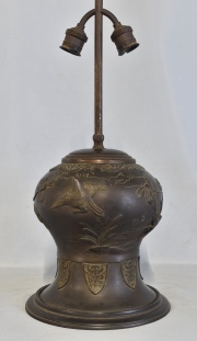 Vaso oriental, trasformado en lámpara. de bronce patinado con ornato de aves entre rameados. Alto 23 cm. Sin pantalla.