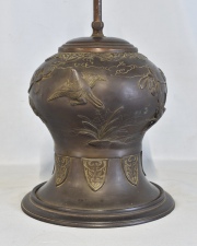Vaso oriental, trasformado en lámpara. de bronce patinado con ornato de aves entre rameados. Alto 23 cm. Sin pantalla.