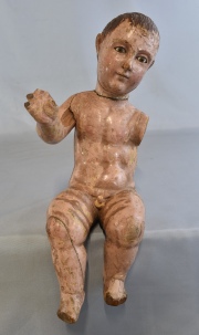 Niño Jesus, talla de madera policromada, ojos de vidrio. Roturas y faltantes. Alto: 35 cm.