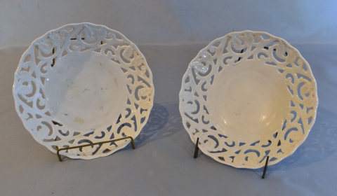 Dos platos blancos calados, de porcelana. Diámetro: 15 cm. .