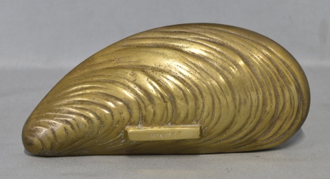 Servilletro de bronce. Melés,en forma de almeja. Frente: 18,5 cm.