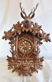 Reloj Cu Cu de madera tallada con figuras de cieros. con pesas. Desperfectos. Alto: 80 cm.