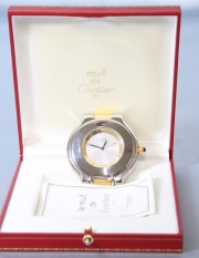 Reloj de viaje Cartier de acero inox y bronce dorado. Alto 6 cm. con estuche.