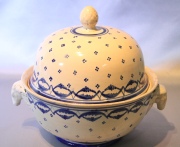 Sopera de faience, crema con decoración azul, cachaduras. Fisuras. Alto: 30 cm. Frente: 34 cm.