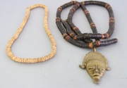 Dos collares, uno con mascarón de bronce.