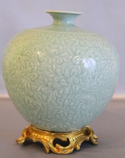 Vaso chino globular de porcelana celadón, con base de bronce. Alto: 28,5 cm.