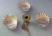 Cuatro Piezas: tres shells de metal plateado y una flor candelero de bronce. .