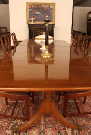 Mesa de comedor estilo Sheraton, de caoba. Regatones de bronce; con dos tablas de agregar.