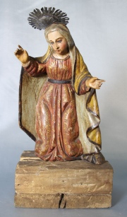 Virgen, talla de madera policromada. Ojos de vidrio; con aureola. Base de madera. Alto: 39 cm.