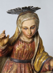 Virgen, talla de madera policromada. Ojos de vidrio; con aureola. Base de madera. Alto: 39 cm.