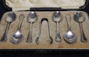 Siete piezas: 6 cucharas de té y pinza, en metal plateado Simmon inglés. En estuche.