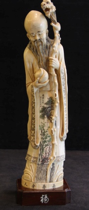 Figura oriental de marfil tallado. Base de madera. Alto total: 36 cm.