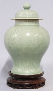 Potiche chino de porcelana con esmalte celadón, leves fisuras. Base de madera con faltantes. Alto potiche: 32 cm.